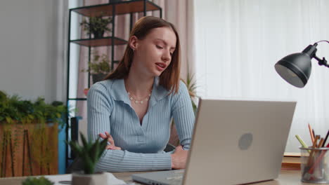 Young-woman-freelancer-at-home-office-making-laptop-video-call-chat-conversation,-working-online