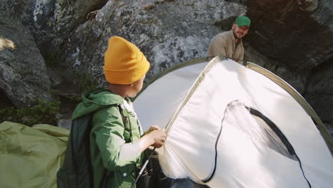 father and son setting up campsite