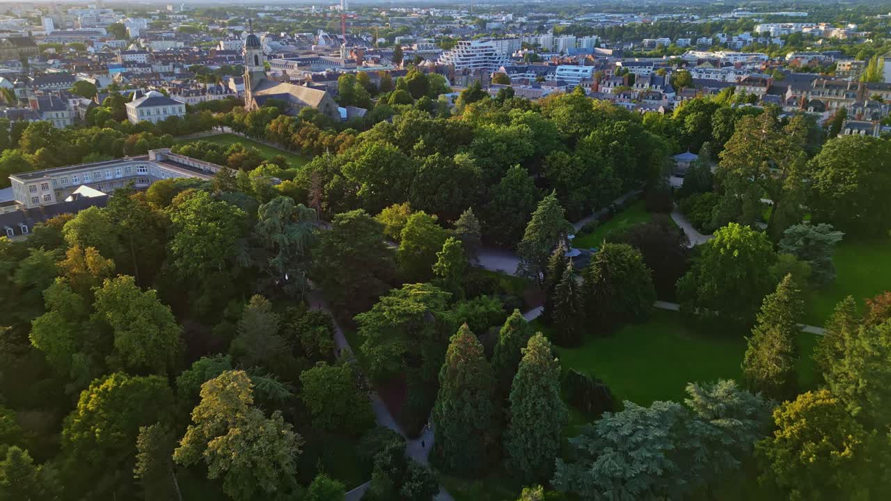 Parc du Thabor or Thabor park with Thabor church in background, Rennes, France. Aerial drone backward