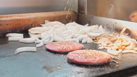 meat and onions being cooked on a hot stove top