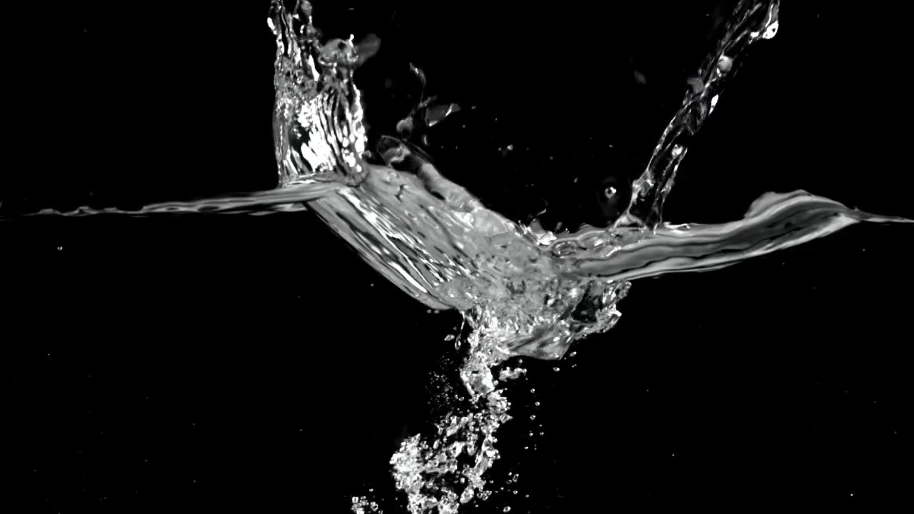 Acqua limpida che si versa e schizza con bolle su sfondo nero