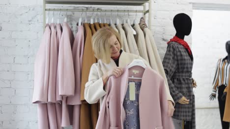 an elderly european woman chooses clothes in a store trying on herself. shopping and shopping