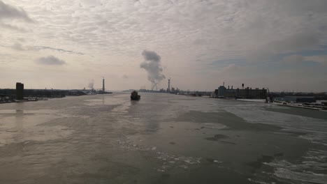 vast detroit river with cargo ship transporting goods, aerial drone view