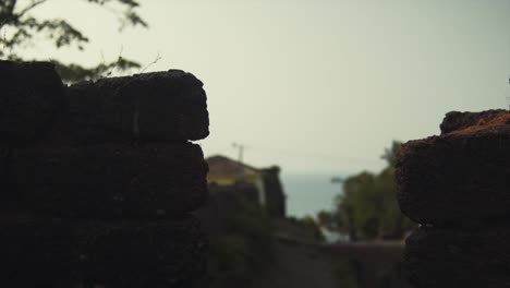 A-silhouette-of-a-pile-of-rocks-with-a-house-in-the-background
