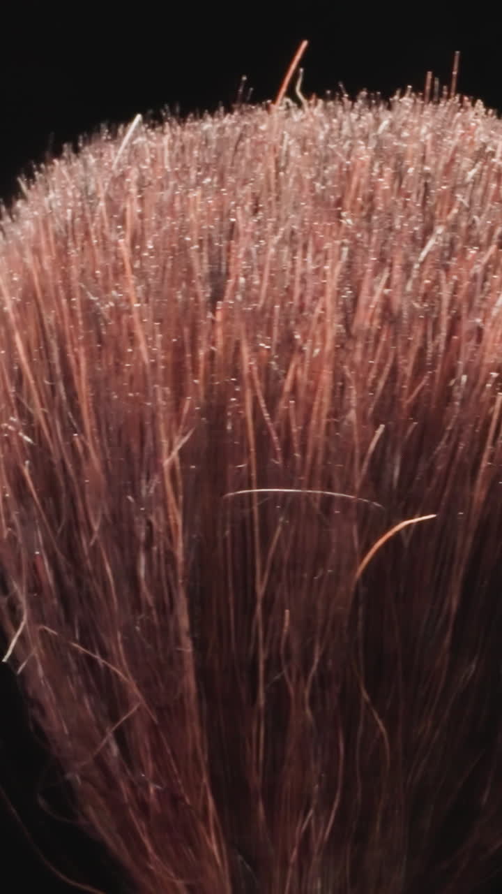 Old cosmetic brush designed for applying powder or blush on face. Professional product for bright facial makeup turning on black background macro