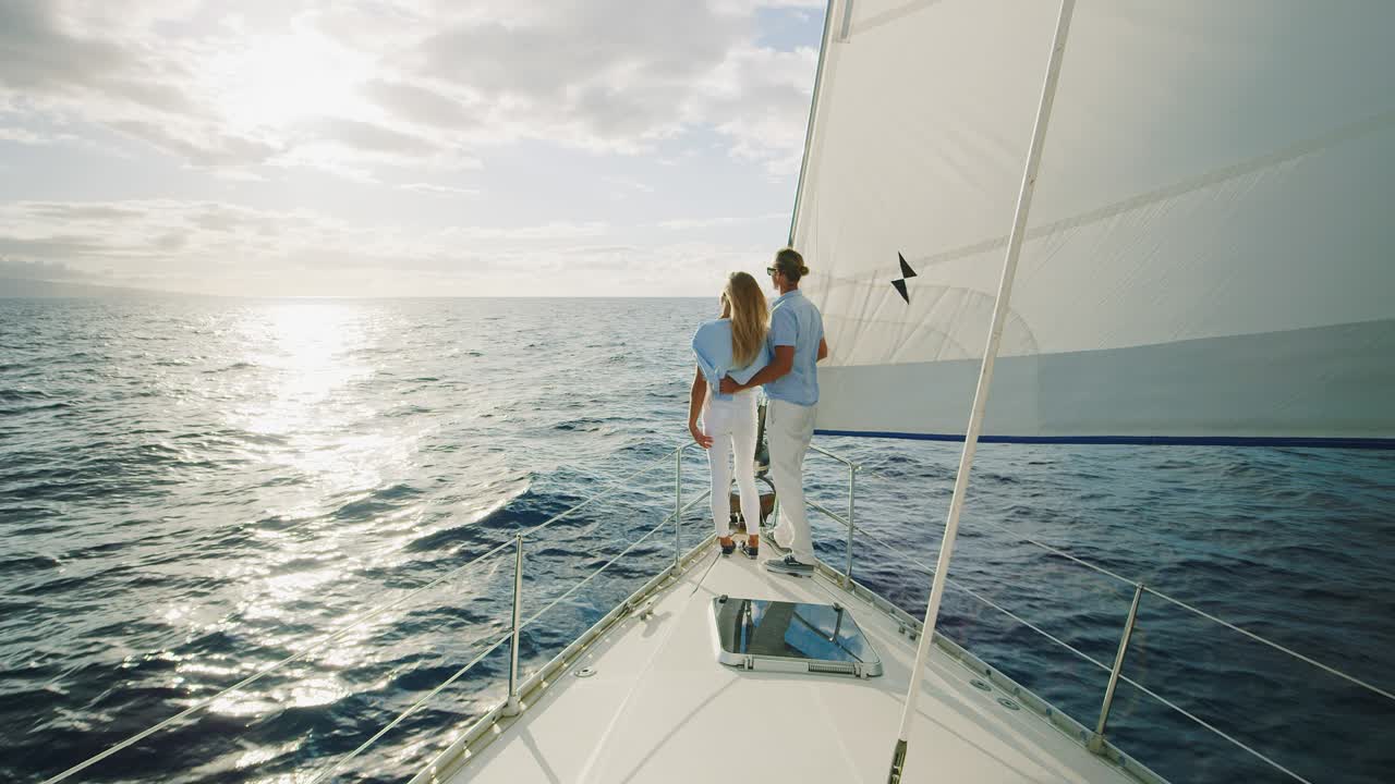 una pareja navegando hacia la puesta de sol.