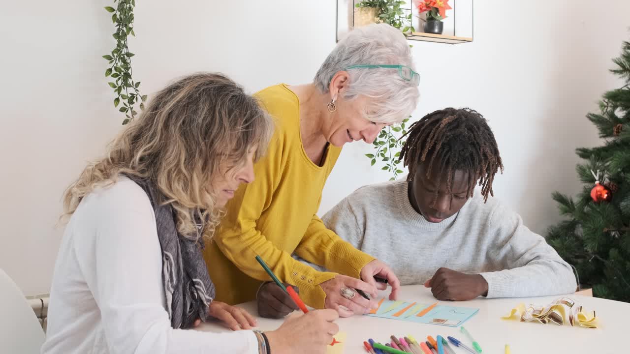 People drawing at a table near a Christmas tree