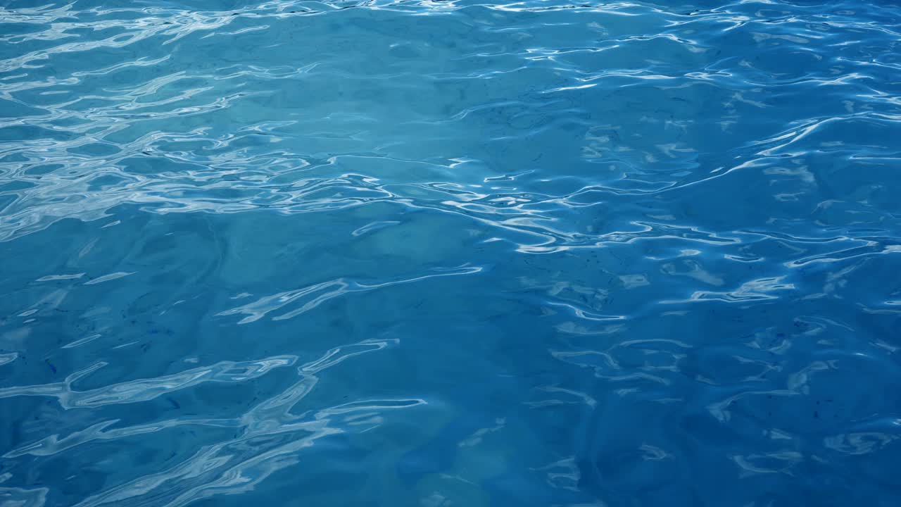 mar o océano, olas vista de cerca. olas azules agua de mar. agua cristalina azul. se puede ver el fondo marino arenoso. olas de mar vista de bajo ángulo. animación 3d 4k loopable