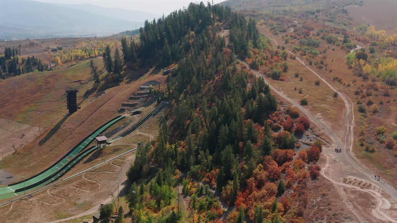 un dron en movimiento lateral de la zona de esquí de howelsen hill en el otoño, junto con algunos senderos para ciclismo de montaña, en steamboat springs, colorado