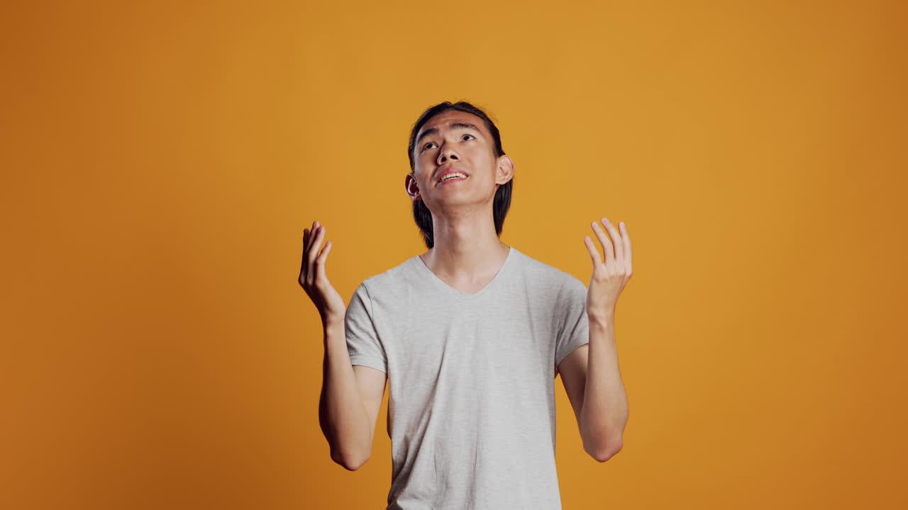 Happy asian man doing prayer hands sign