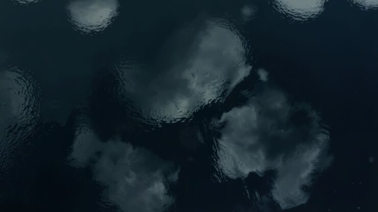 Showing dark water shifting cloud reflections, rippling from light wind at dusk with highlights