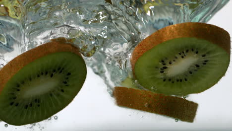 rebanadas de kiwi que caen en el agua