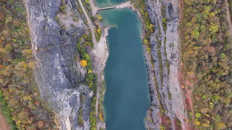 Birdseye-Aerial-View-of-Massive-Abandoned-Limestone-Quarry-in-Czech-Republic-on-Autumn-Day