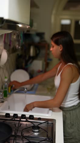 mujer lavando platos en la cocina