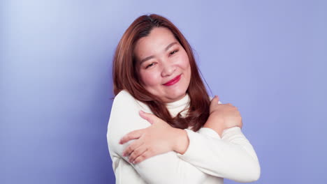 young beautiful woman feeling in love, smiling, cuddling and hugging herself being selfish on purple background-2