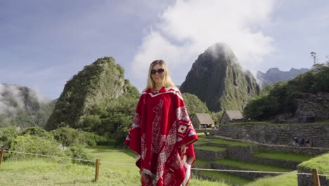 happy tourist woman with peruvian poncho spinning in machu picchu. joy of traveling. wanderlust traveler peru