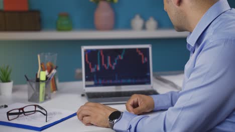 el hombre que mira el gráfico de criptomonedas es infeliz. pérdida en el mercado de valores.