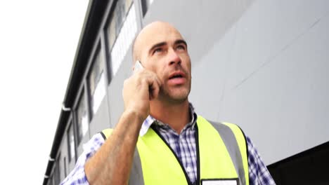 Welder-talking-on-phone-outside-workshop