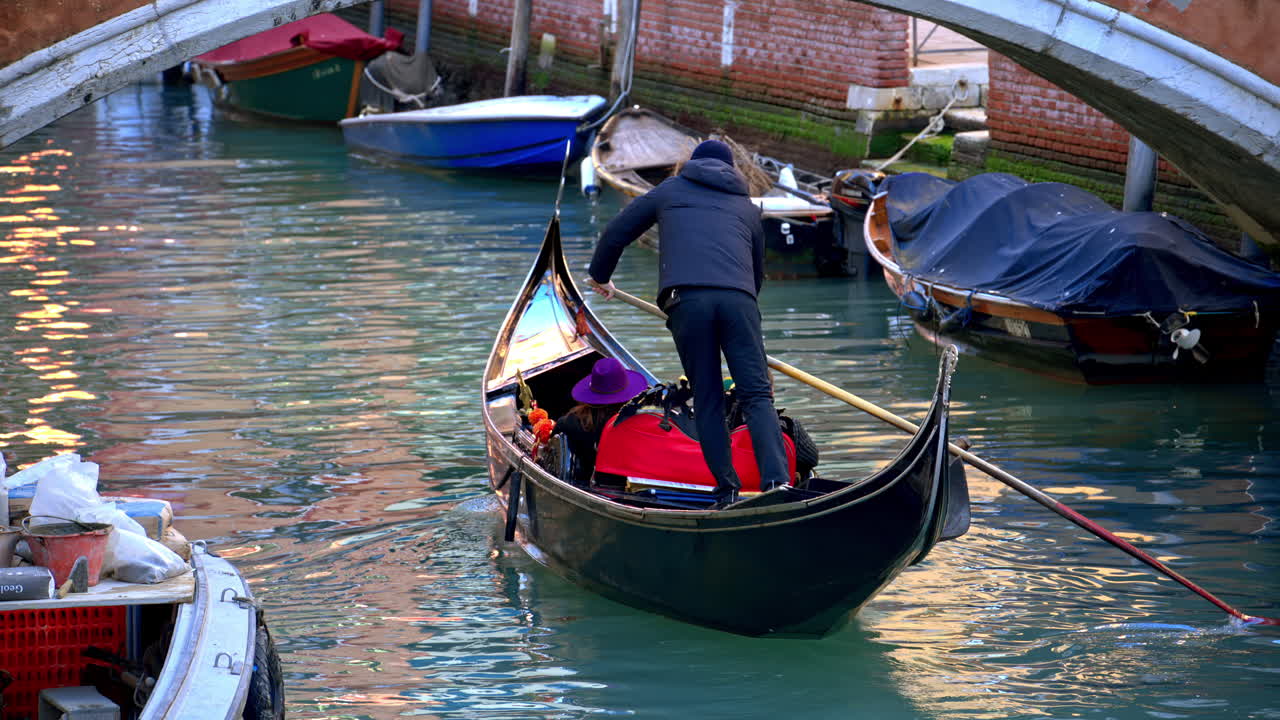People riding in a gondola boat through Venice City, Italy