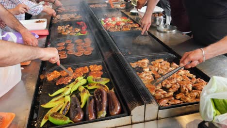 large group enjoying grilled food at a street food stall