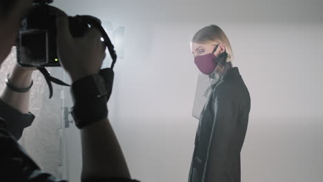 female model in face mask posing for photographer in studio