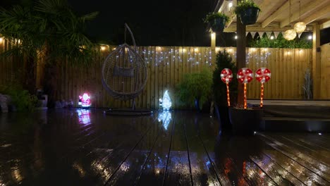 outdoor footage of a minimalistic garden at night with warm lighting, fairy lights and christmas decorations