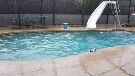 Panning-view-of-enclosed-backyard-pool-during-rain-in-Florida