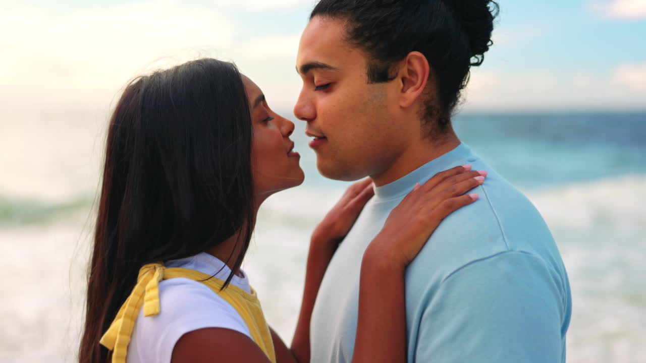 Amore, appuntamento e una coppia che si bacia sulla spiaggia