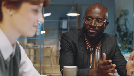 african american businessman talking with colleague at night meeting