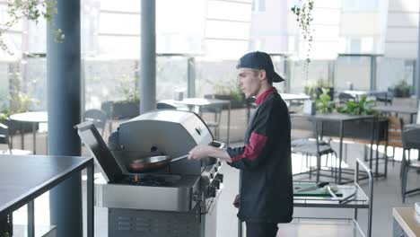 chef cooking outdoors on gas grill