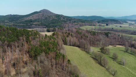 Flying-above-a-hilly-landscape-with-forests-and-meadows-in-Czechia,-Europe