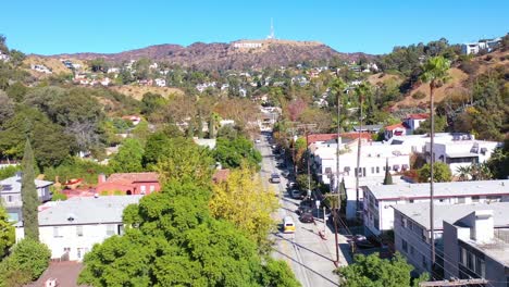 aerial above beachwood drive in hollywood with cars driving up towards hollywood sign