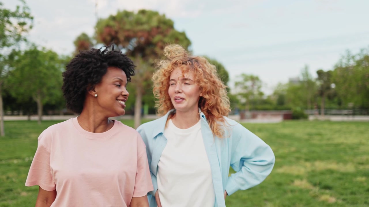 Two Happy Young Women Talking and Laughing Outdoors