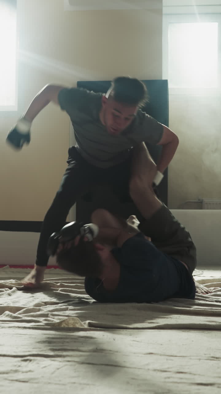 el atleta lanza al tipo que se defiende del ataque del compañero en el club deportivo. los deportistas entrenan para divertirse en el gimnasio de niebla a cámara lenta. las técnicas de combate muestran