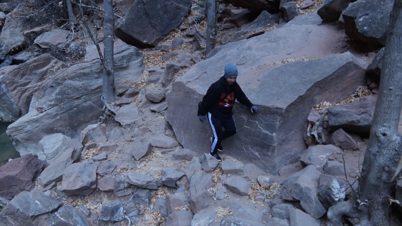 joven caminando sobre rocas rojas en el parque nacional zion, utah