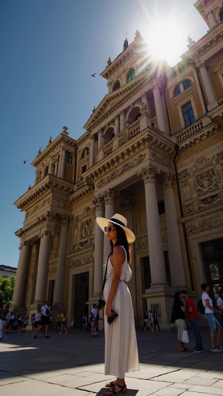 Turista con fotocamera in piedi di fronte a un edificio storico europeo