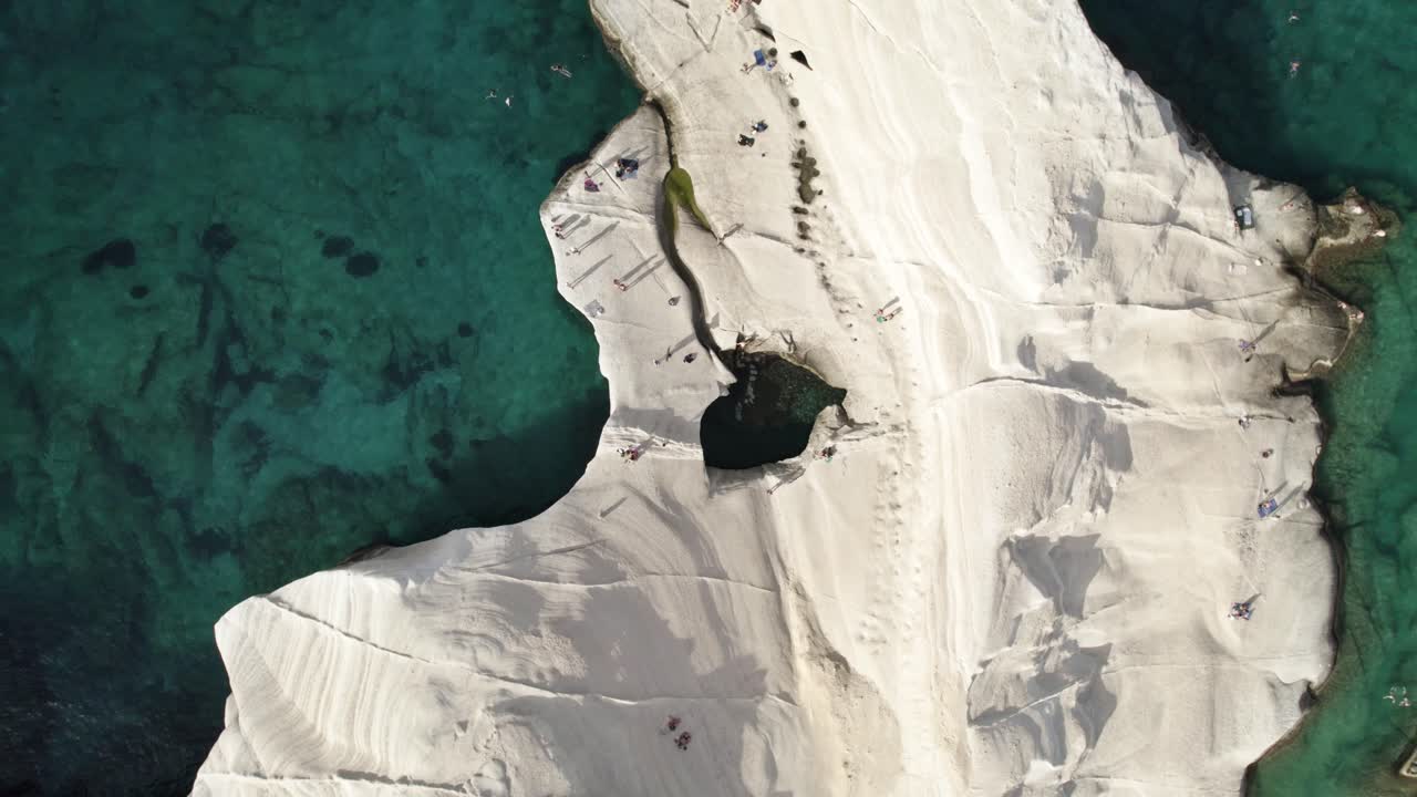 la gente rodea una piscina azul turquesa brillante a lo largo de la costa mediterránea