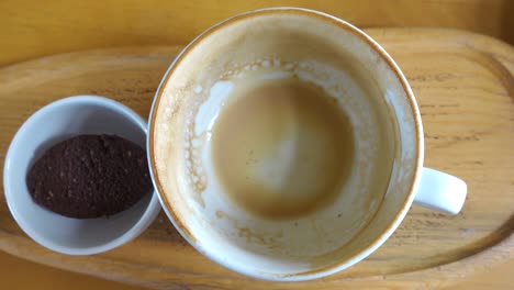 empty coffee cup with cookie on wooden tray