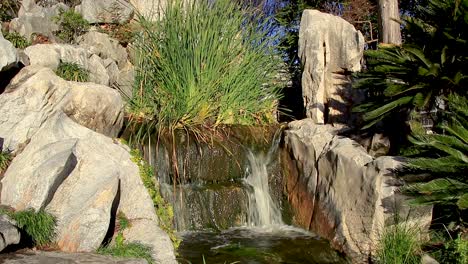 waterfall flowing over rocks in a chinese garden on a summers day
