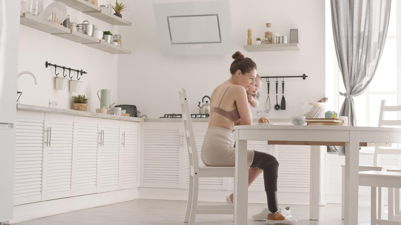 Businesswoman with Leg Prosthesis Working while Babysitting