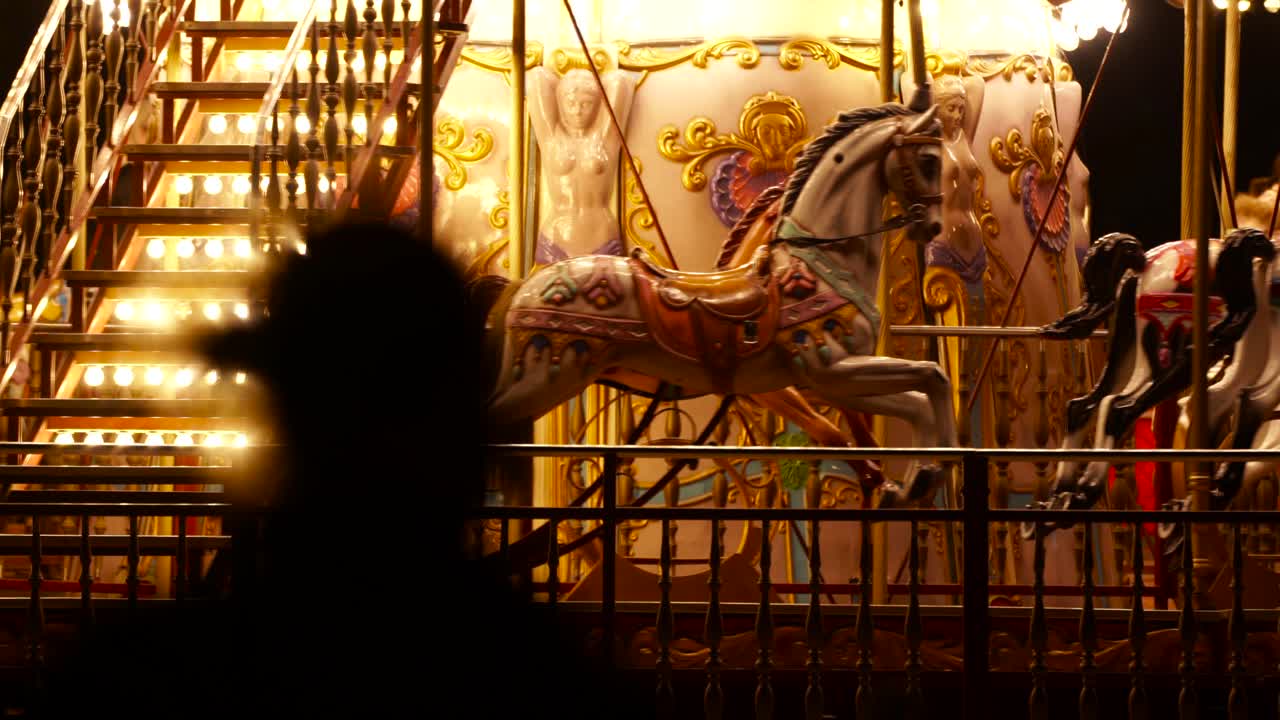 caballos dentro de un carrusel en movimiento, una rotonda o un tiovivo con luces de colores