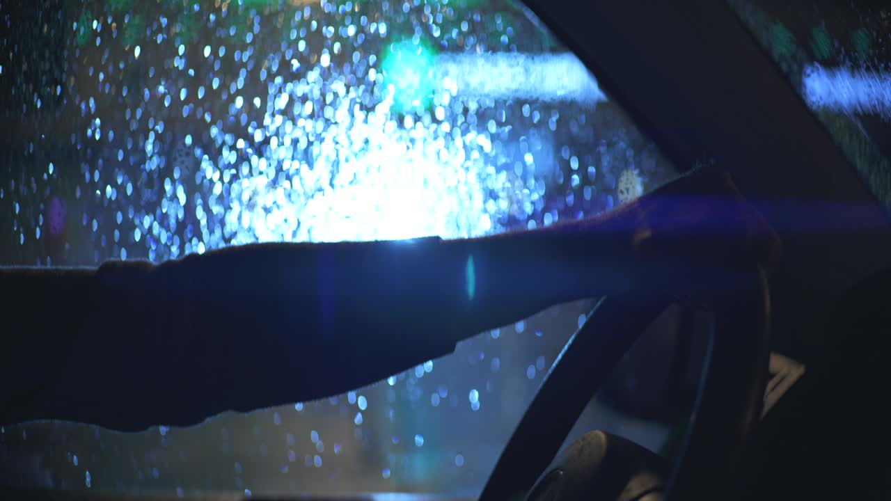 그 남자는 비가 오는 밤에 스티어링 을 들고 있다.