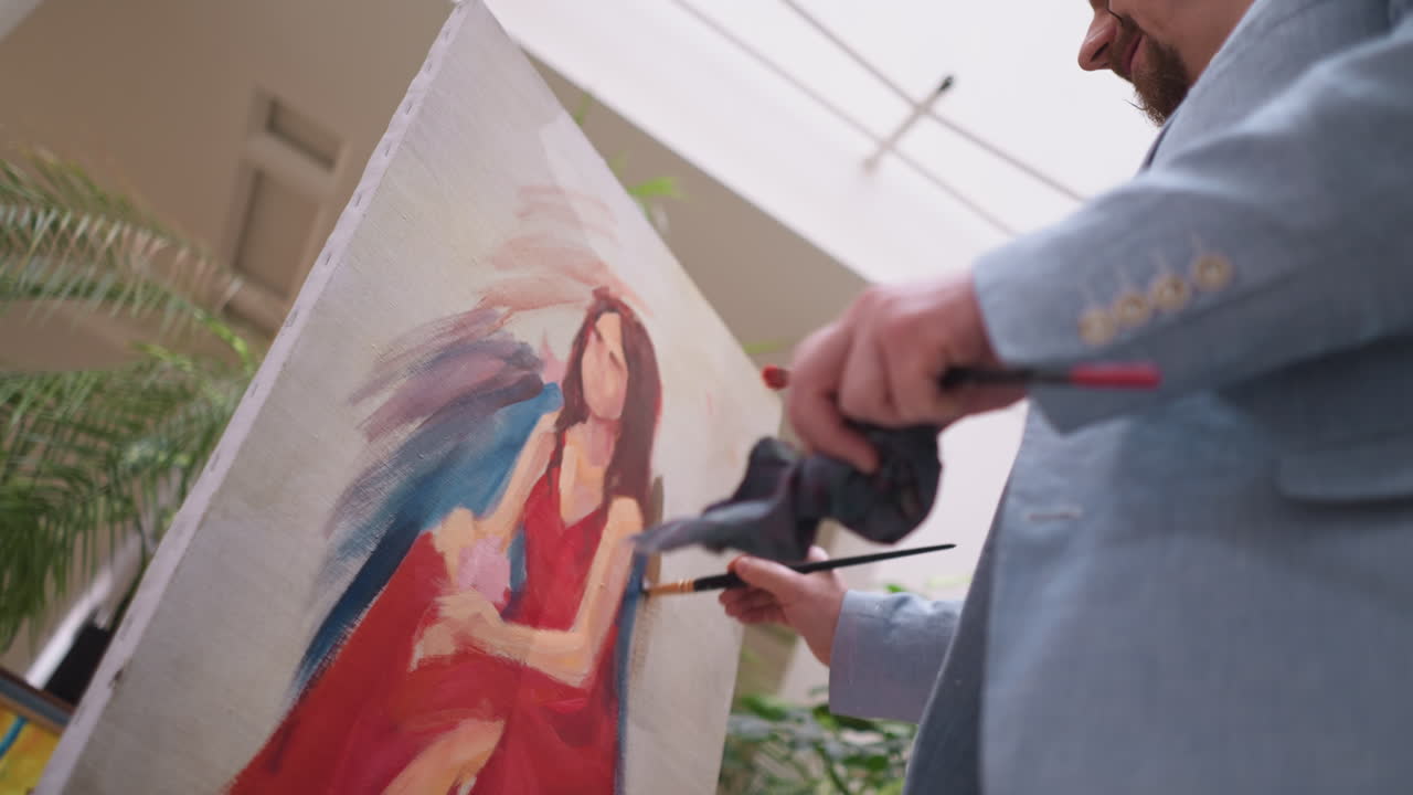 예술가는 여성 초상화에 색소를 혼합합니다. 전문 화가는 미술 스튜디오에서 캔버스에 색의 조화로운 균형을 만니다. 예술의 진정성
