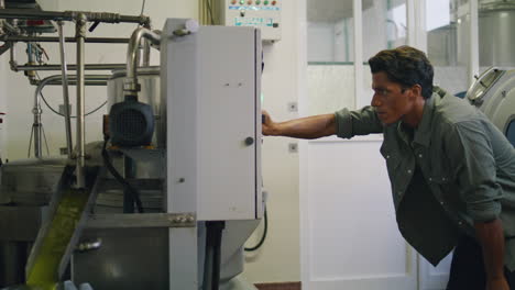 focused guy pushing buttons at press indoors close up. man worker tapping screen