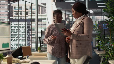 due donne d'affari che discutono di un progetto su un tablet in un ufficio moderno