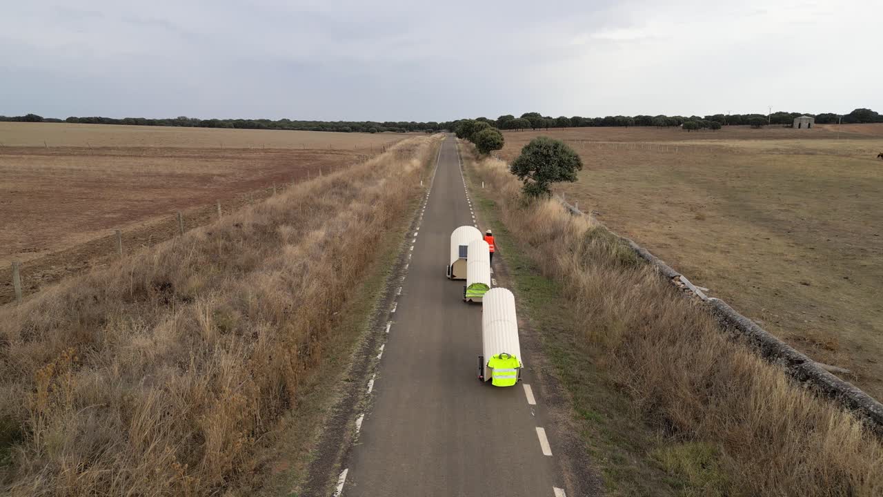 Nomad family pulling small homes on wheels in countryside in Spain