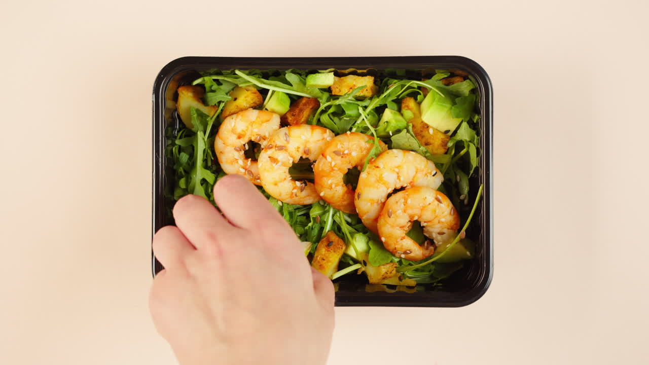 Aggiunta di gamberetti e spremitura di lime su un'insalata sana