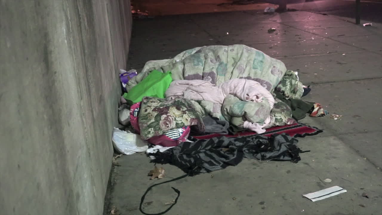 Blankets and meager possessions of a homeless man