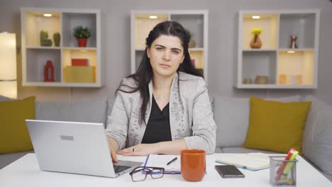 trabajadora de oficina en casa que se ve aburrida ante la cámara.