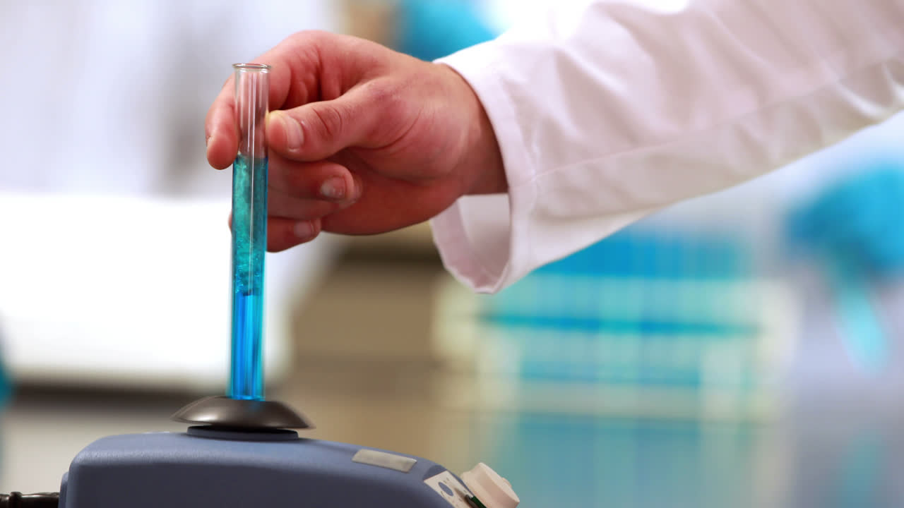 científico mezclando tubo de ensayo con centrifugadora
